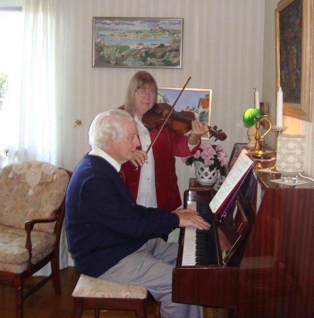 En man och en kvinna spelar fiol och piano