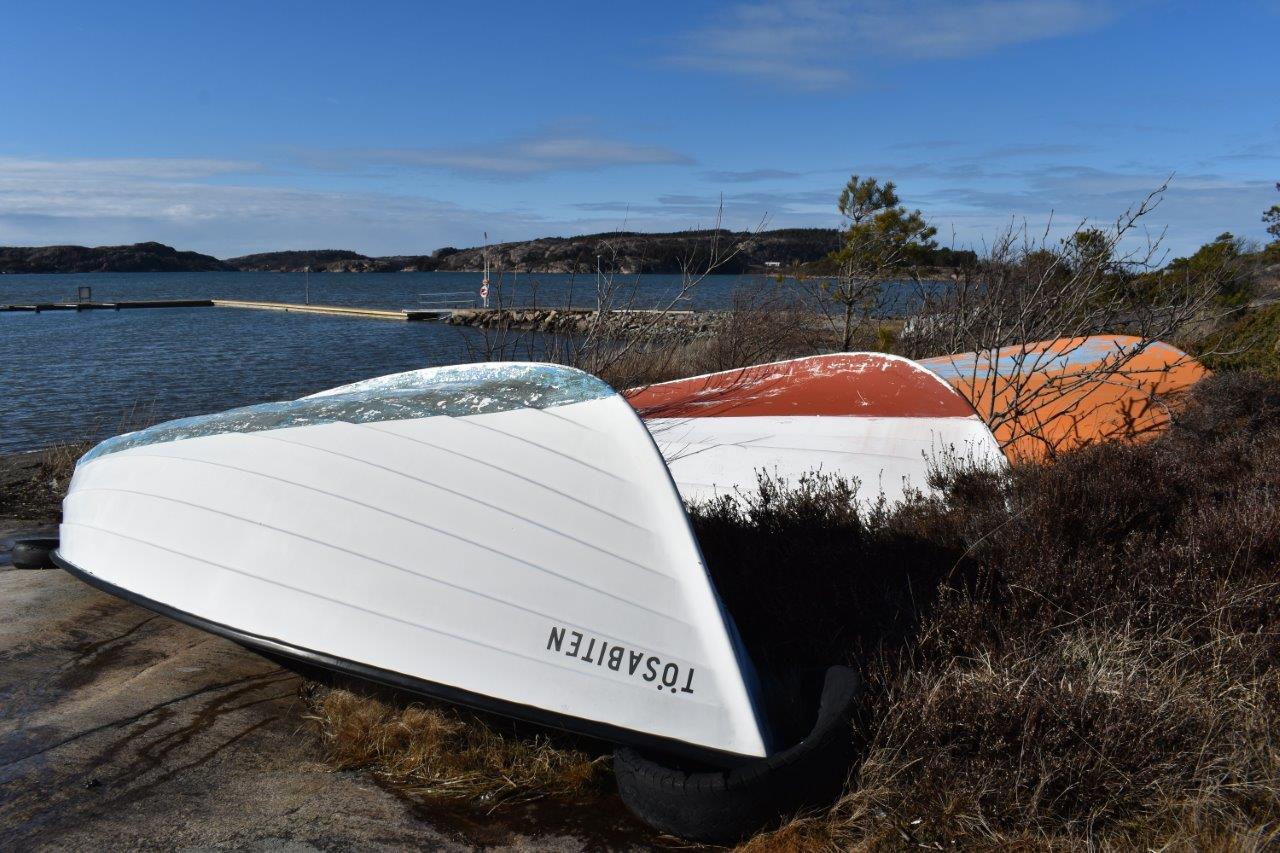 Byggor och sandstrand under tunga fluffiga måln.
