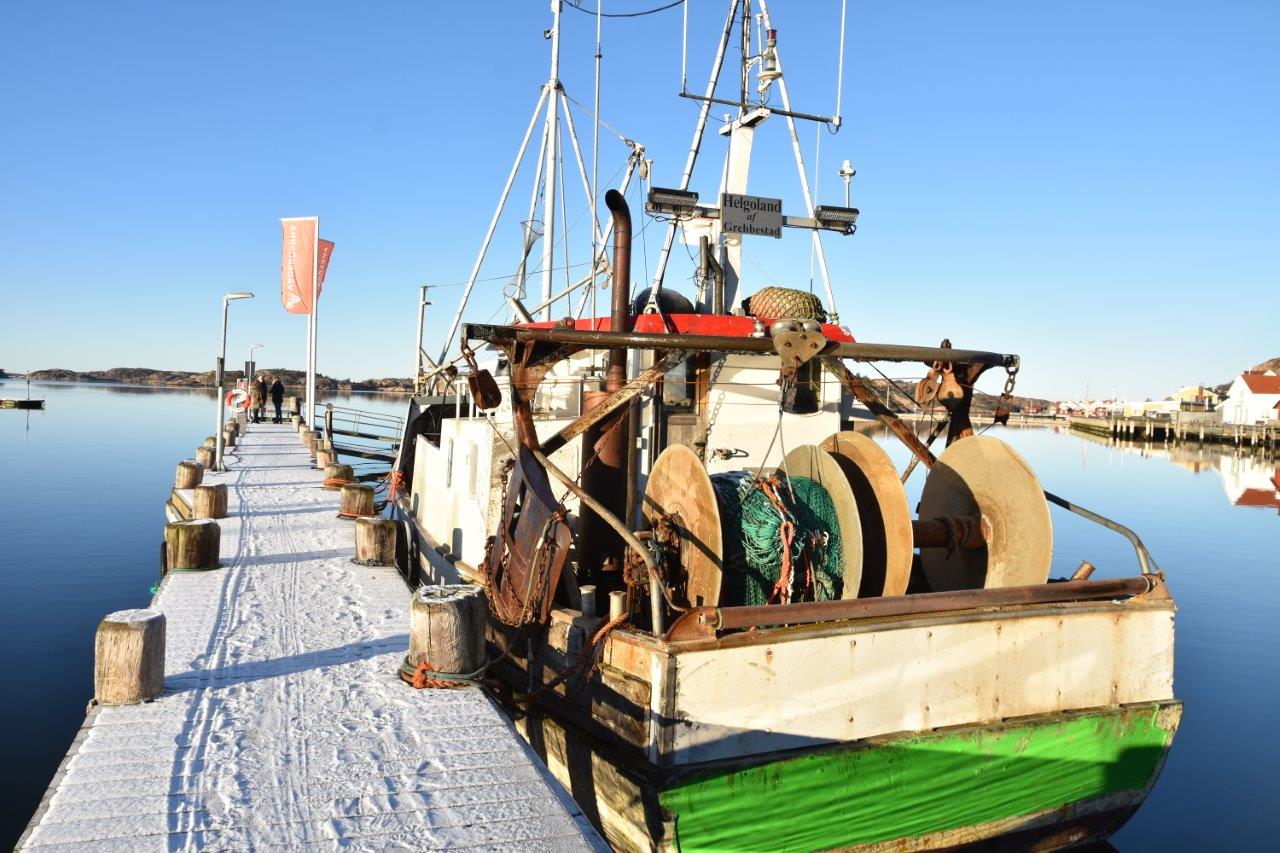Fiskebåt vid en snöig brygga i Fjällbacka
