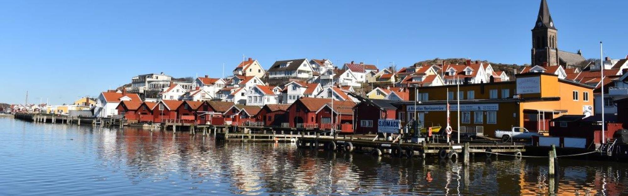 Hus, sjöbodar och kyrka i Fjällbacka sett från havet